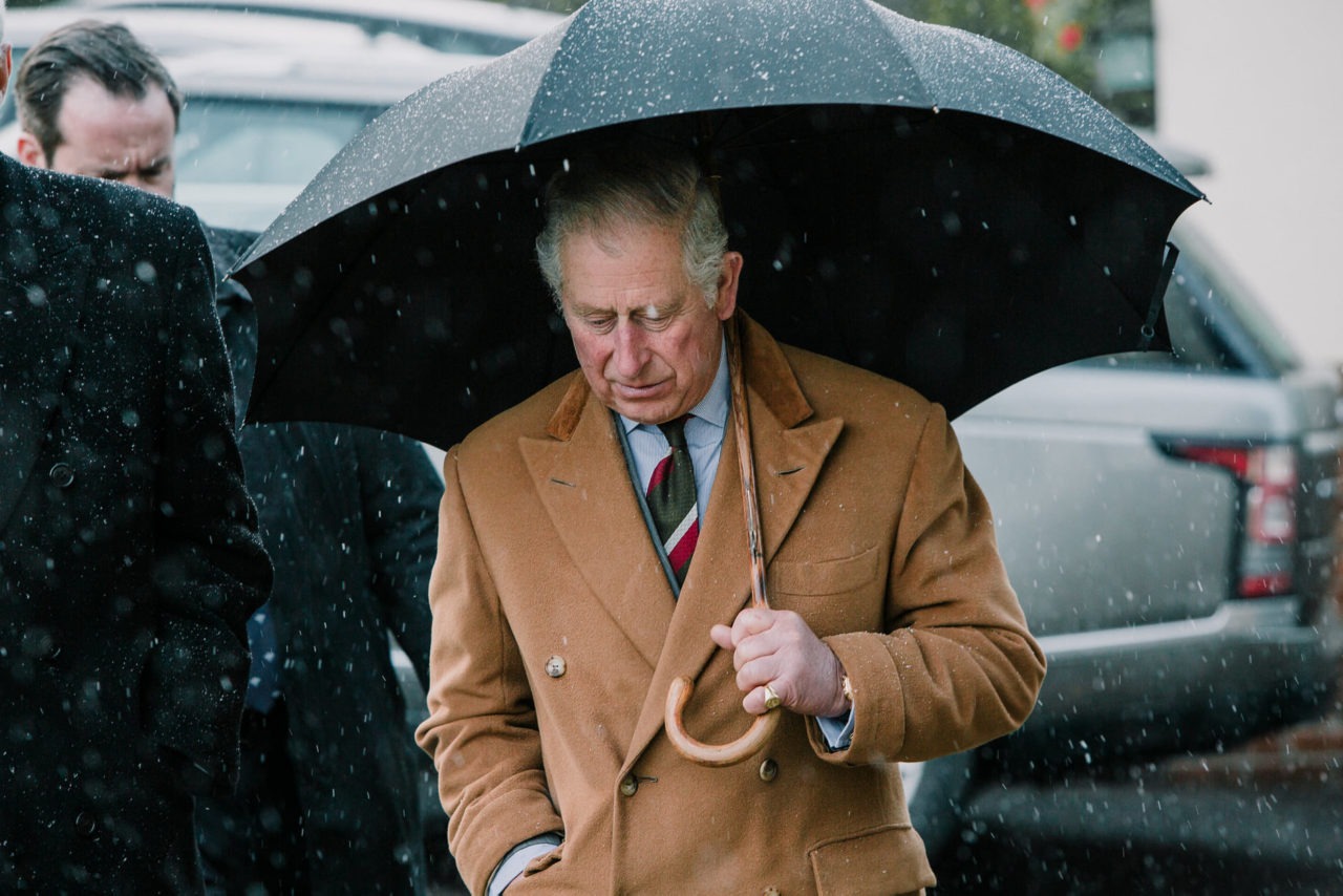 Prince Charles under an umbrella in the snow