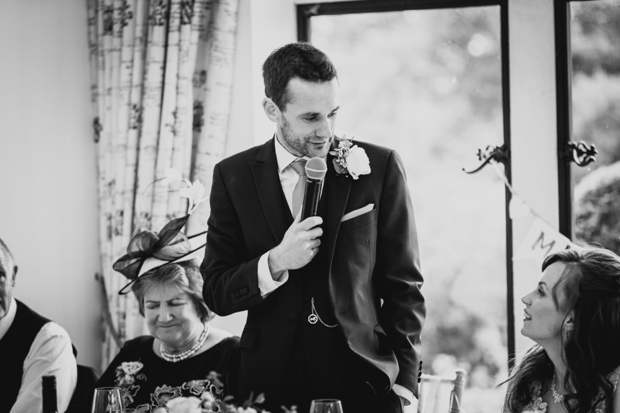 Richard looking at Donna while giving a speech into a microphone