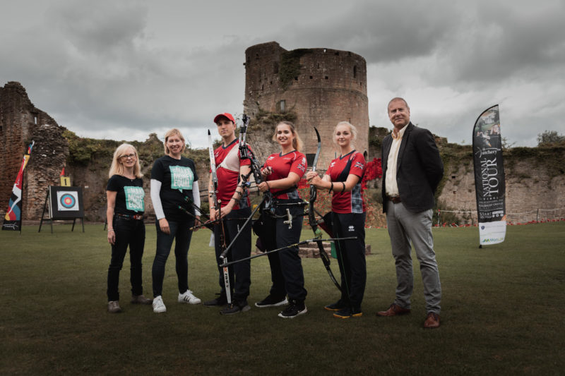 GB Archery team stood with bows in front of moody looking castle