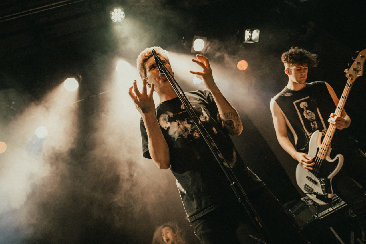 Singer holding hands up in stage in angst