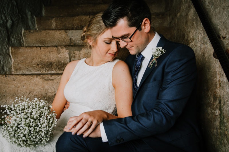 Couple sat on stone steps hand in hand