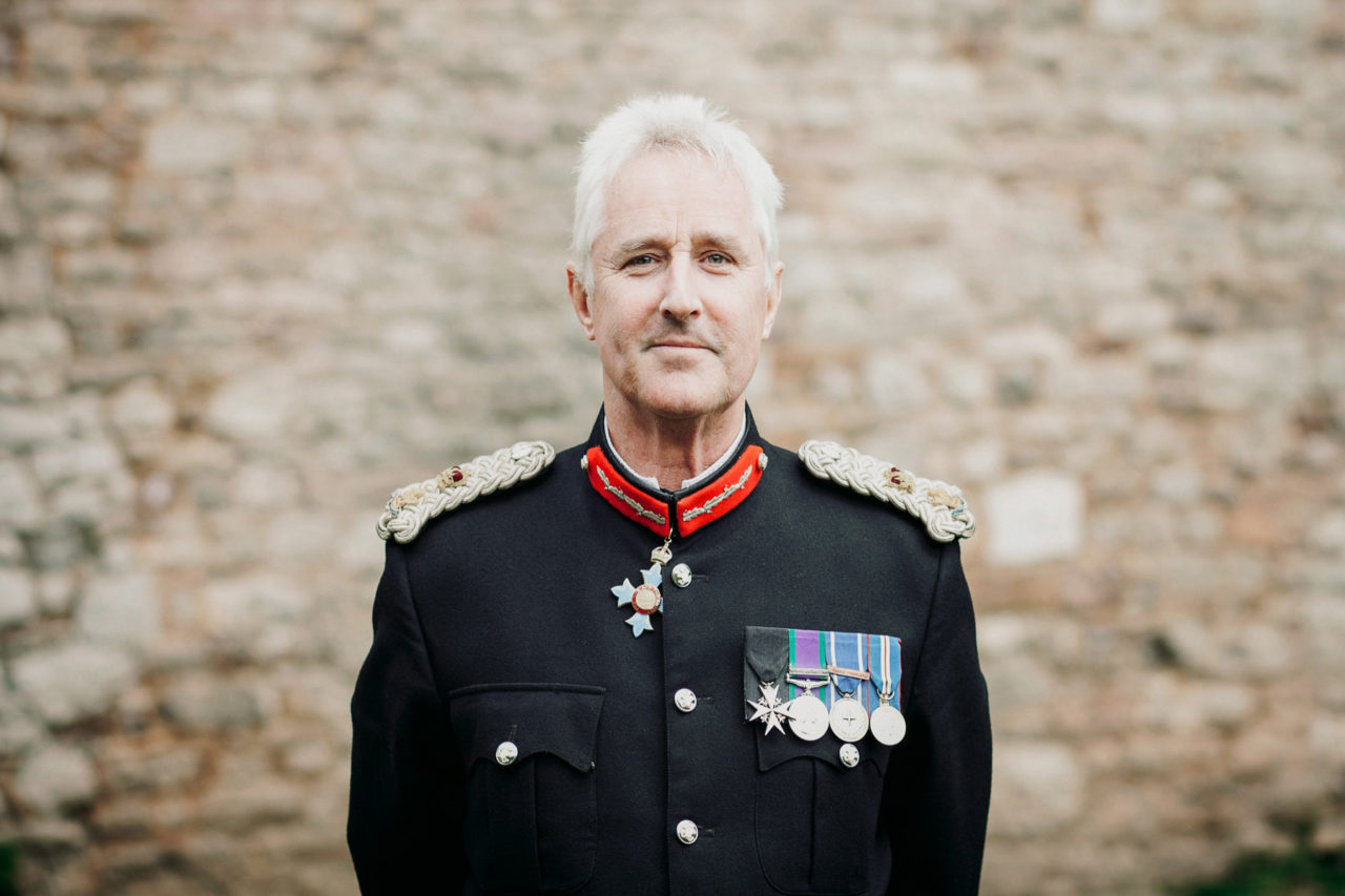 Lord Lieutenant of Gwent stood relaxed with hands behind back smiling 