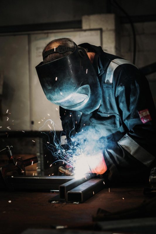 Welder with mask as sparks fly everywhere