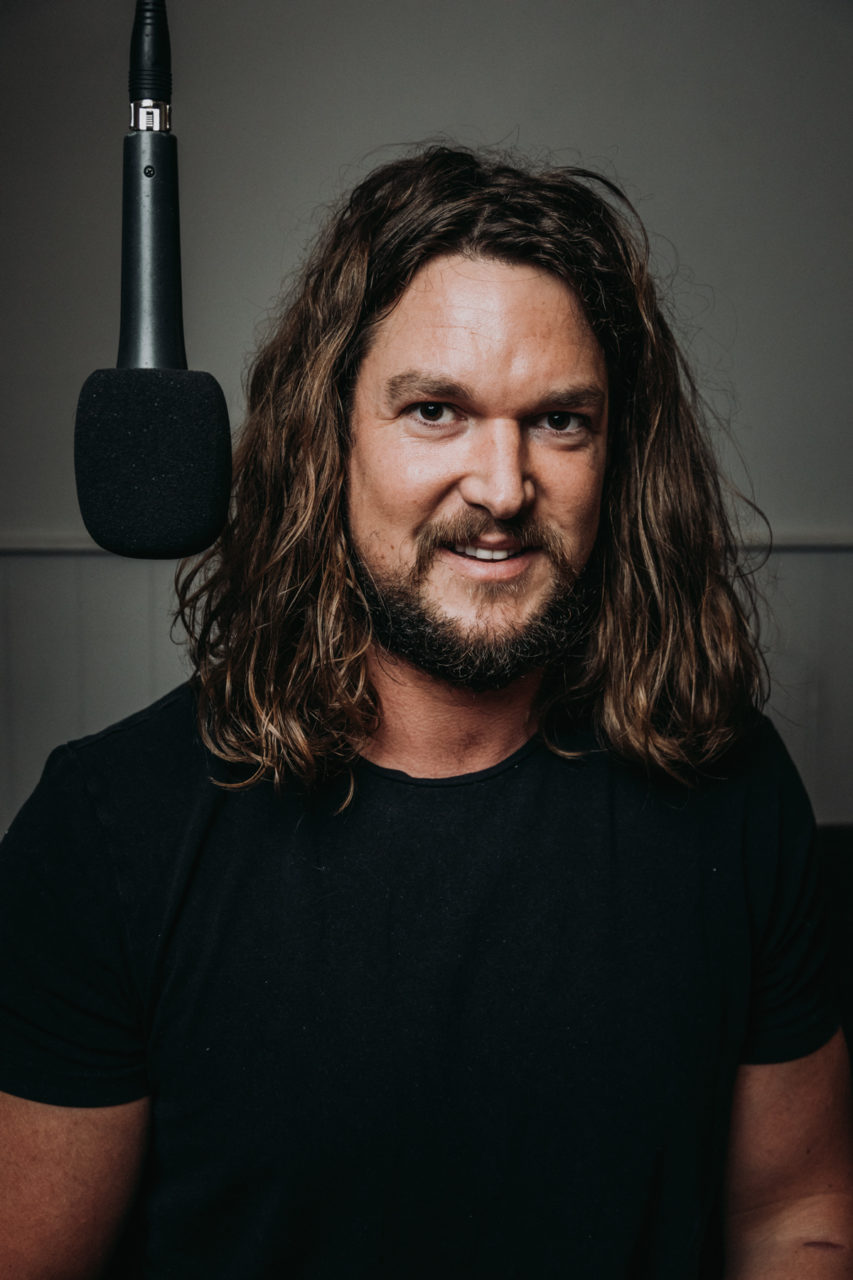 Gaz smiling next to microphone