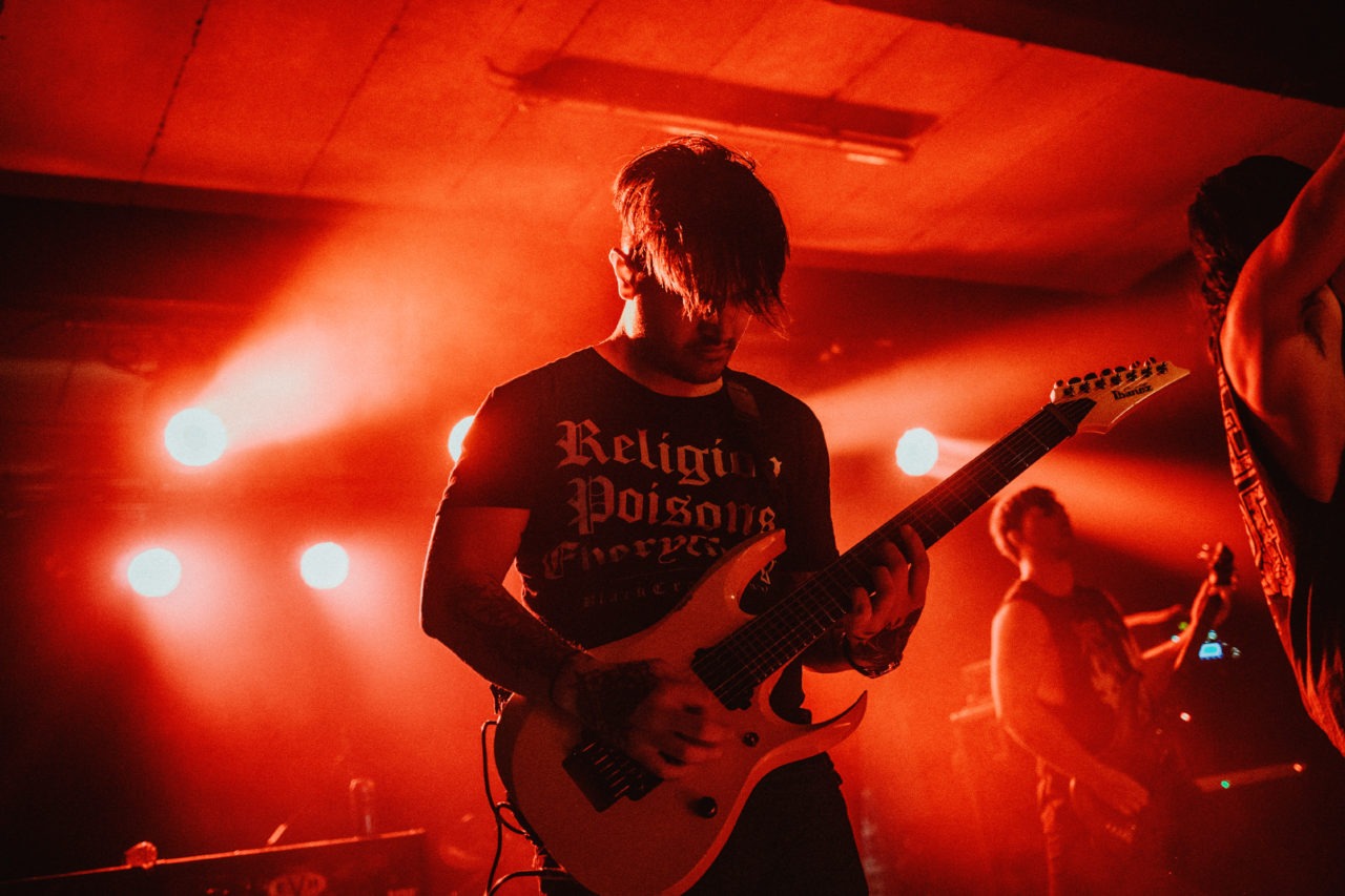 Deathcore guitar player bathed in red light