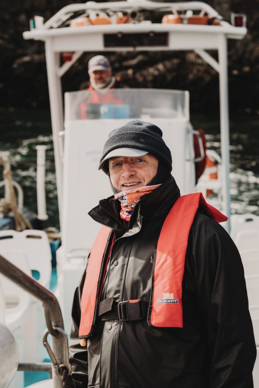 Man on boat in life jacket smiling at the camera