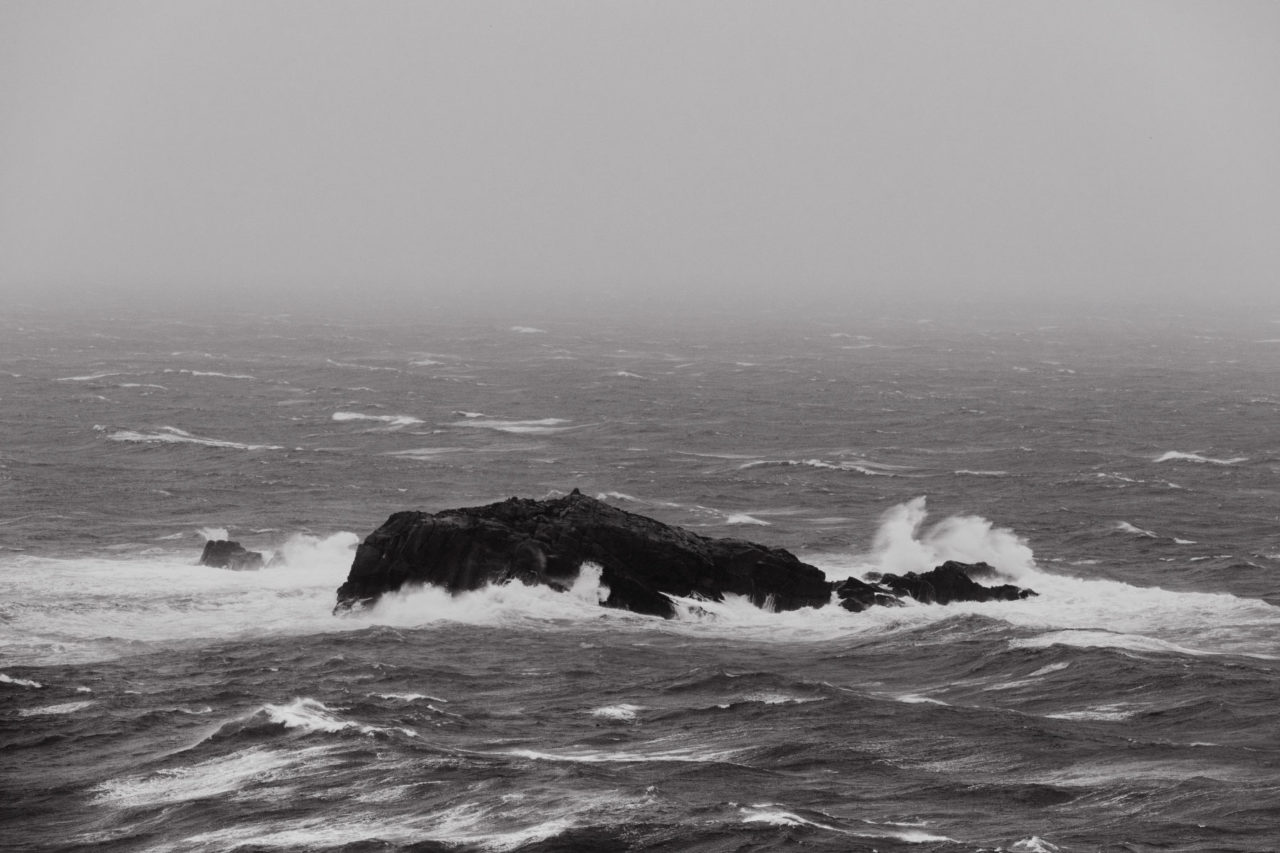 Island being battered by the ocean during a storm