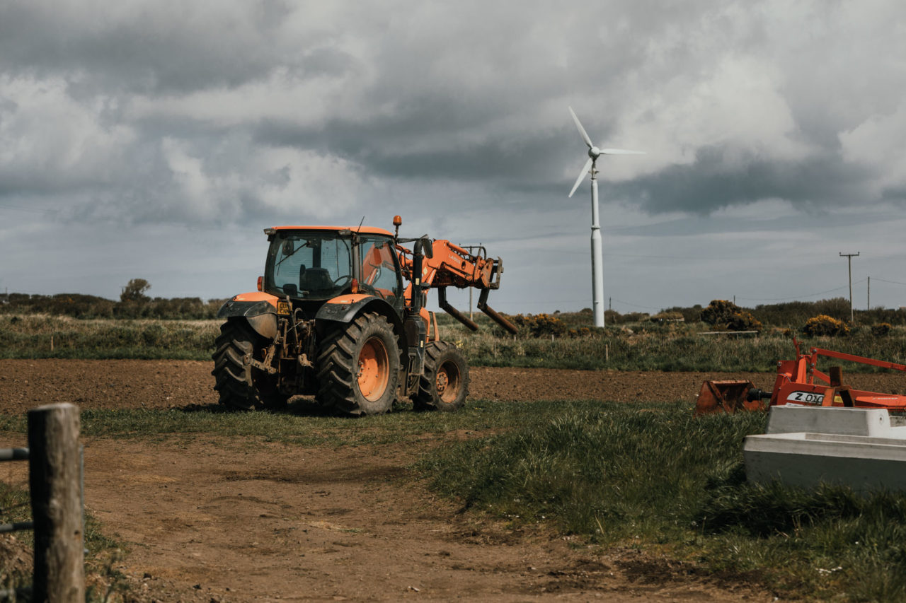 Orange tractor sat abandoned in field