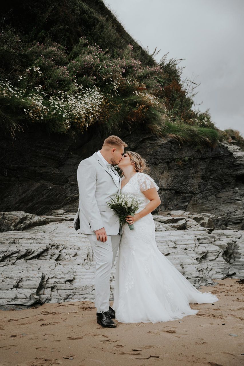 Newly weds kissing on beach