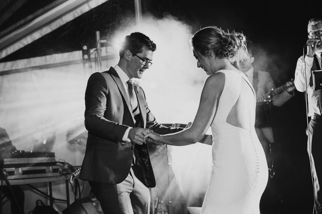 Newly weds dancing together against backlight