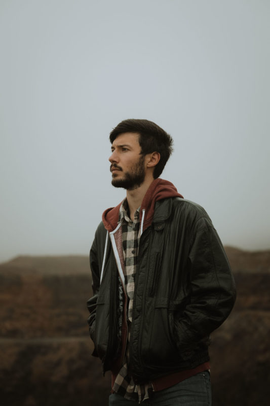 Man stood with hands in pockets in a misty grey quarry