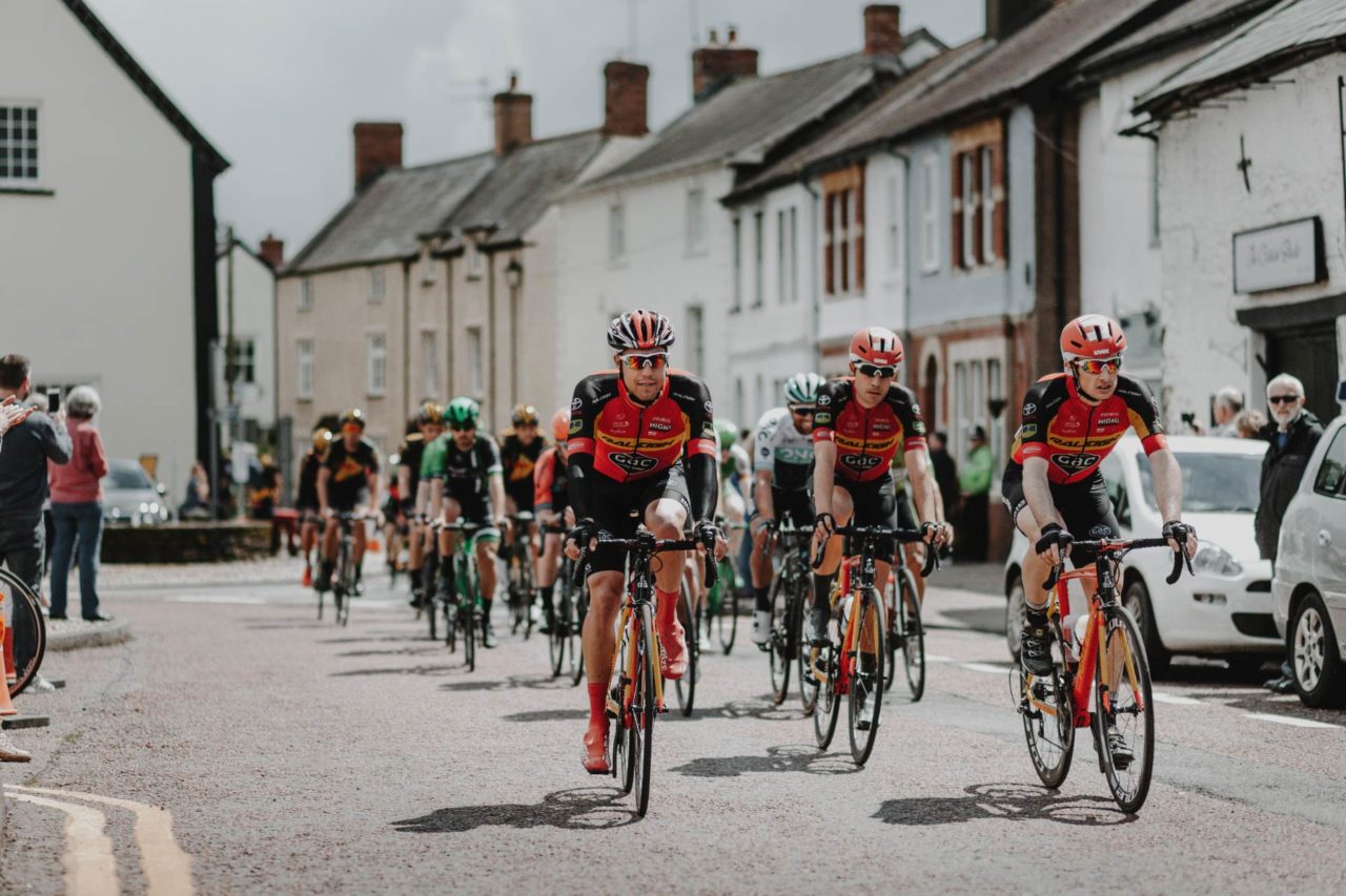 Pro cyclists racing through the street towards the camera