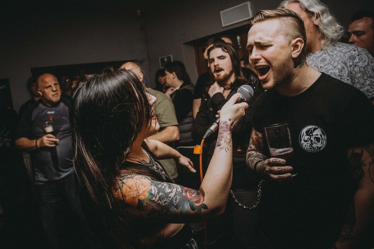 Female singer holding microphone into fan's faces while they sing