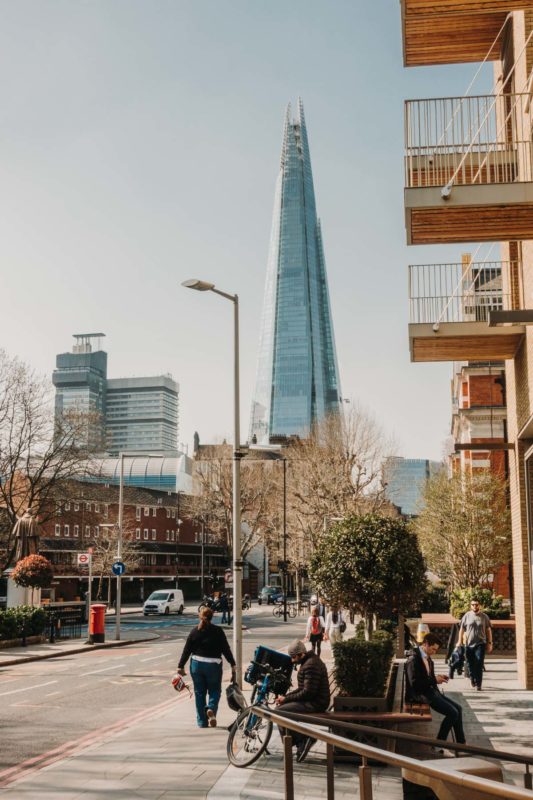 Snap shot from a London street with the Shard towering in the background on a sunny day