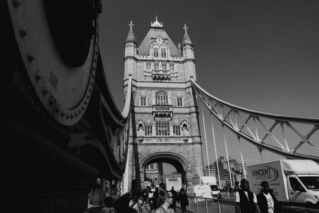 Black and white view of Tower Bridge with pedestrians walking across