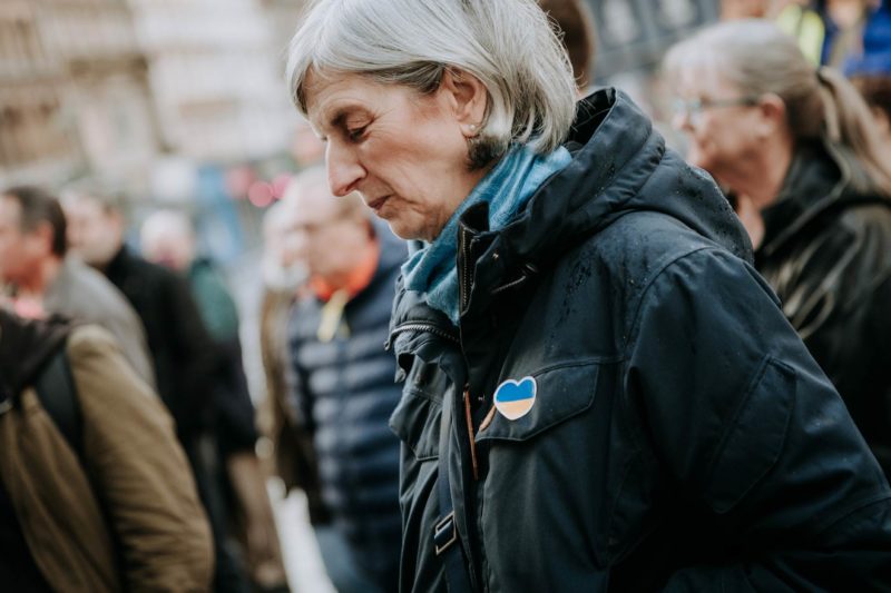 A sad looking lady with her head bowed and eyes closed