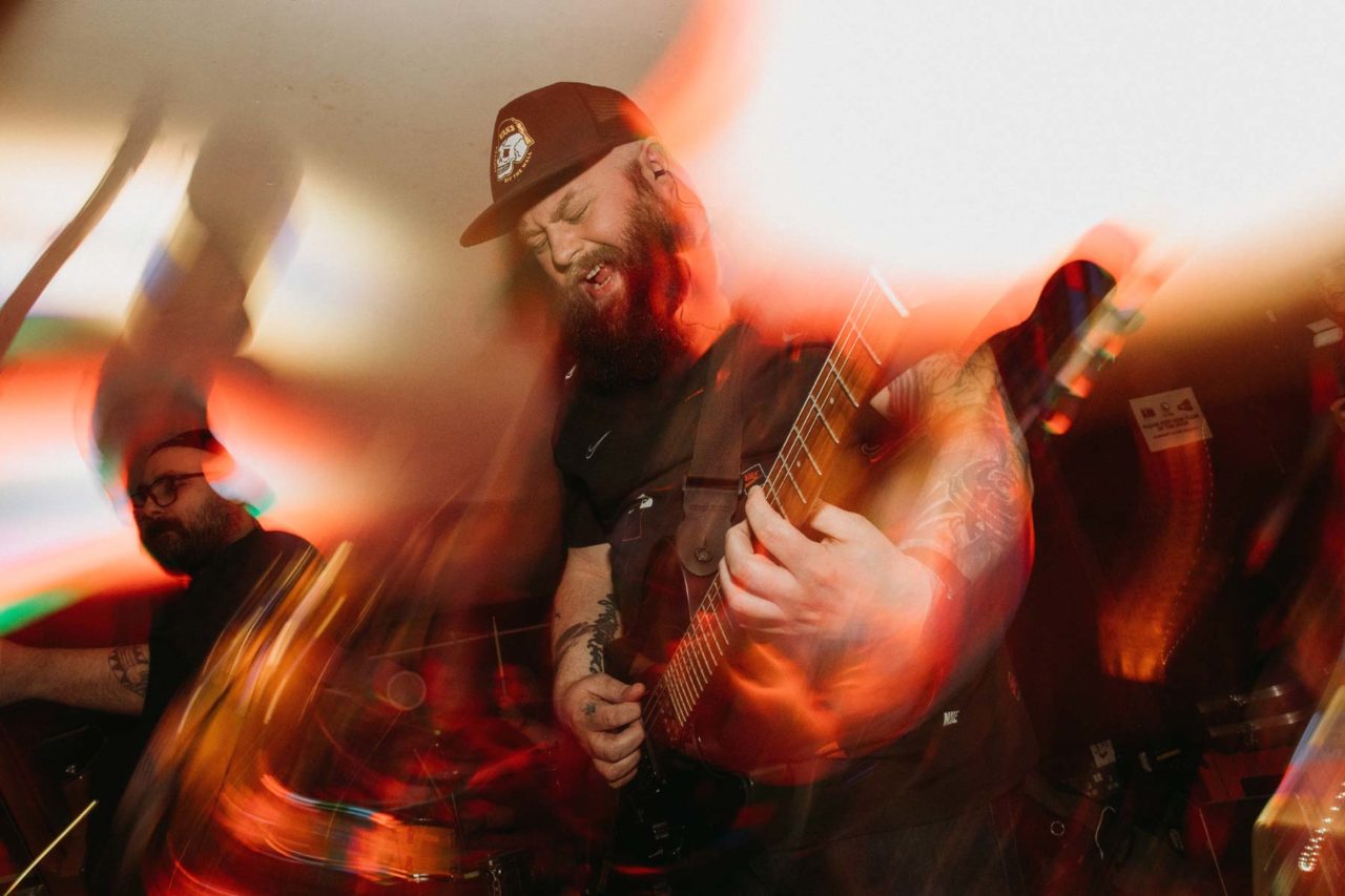 Emotional guitarist on stage surrounded in light and motion