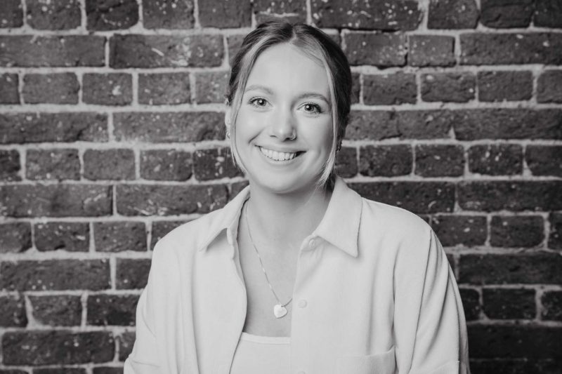 Black and white close up of woman smiling to the camera during a studio shoot