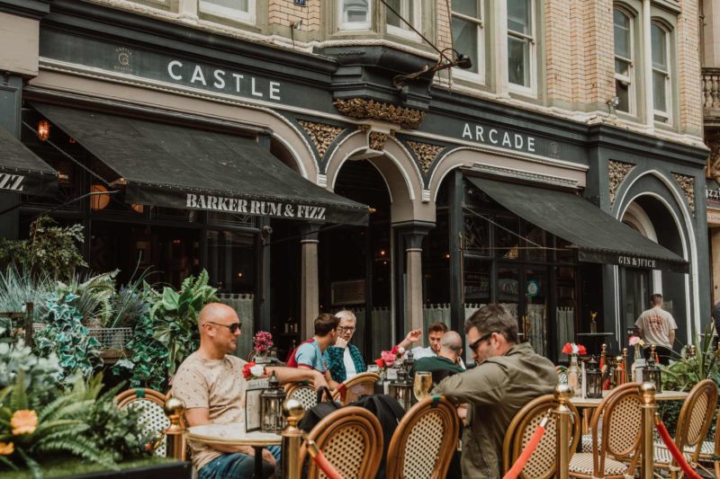 Exterior shot of people sat outisde of Castle Arcade in Cardiff