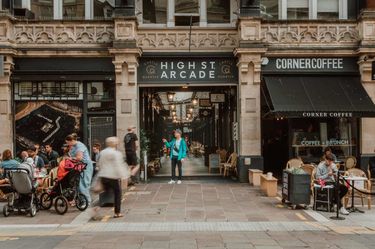 The front of High Street Arcade in Cardiff with people walking past