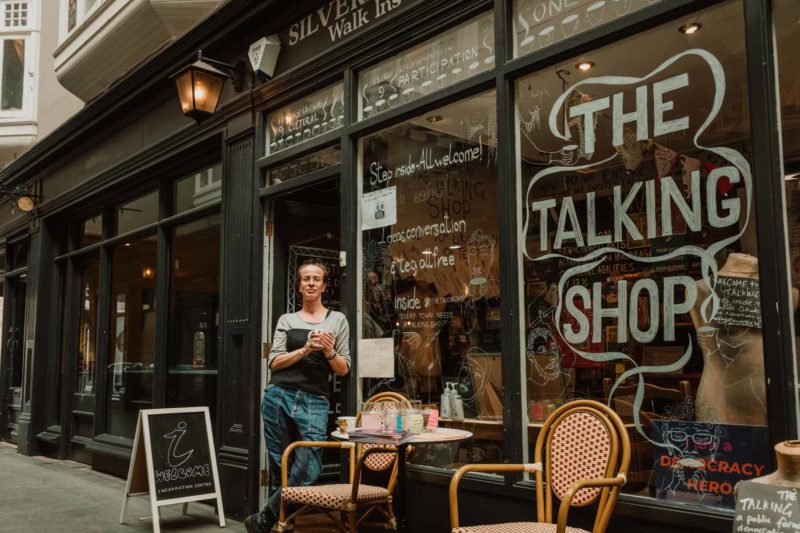 Friendly female manager of the Talking Shop stood smiling inside of Castle Arcade