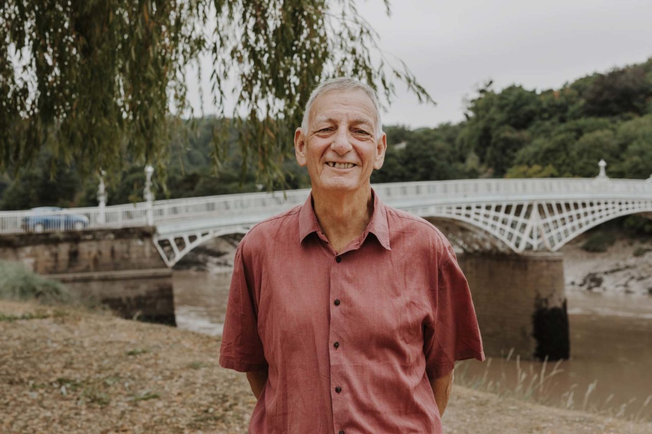 Friendly man stood in red shirt smiling with River Wye behind him in South Wales