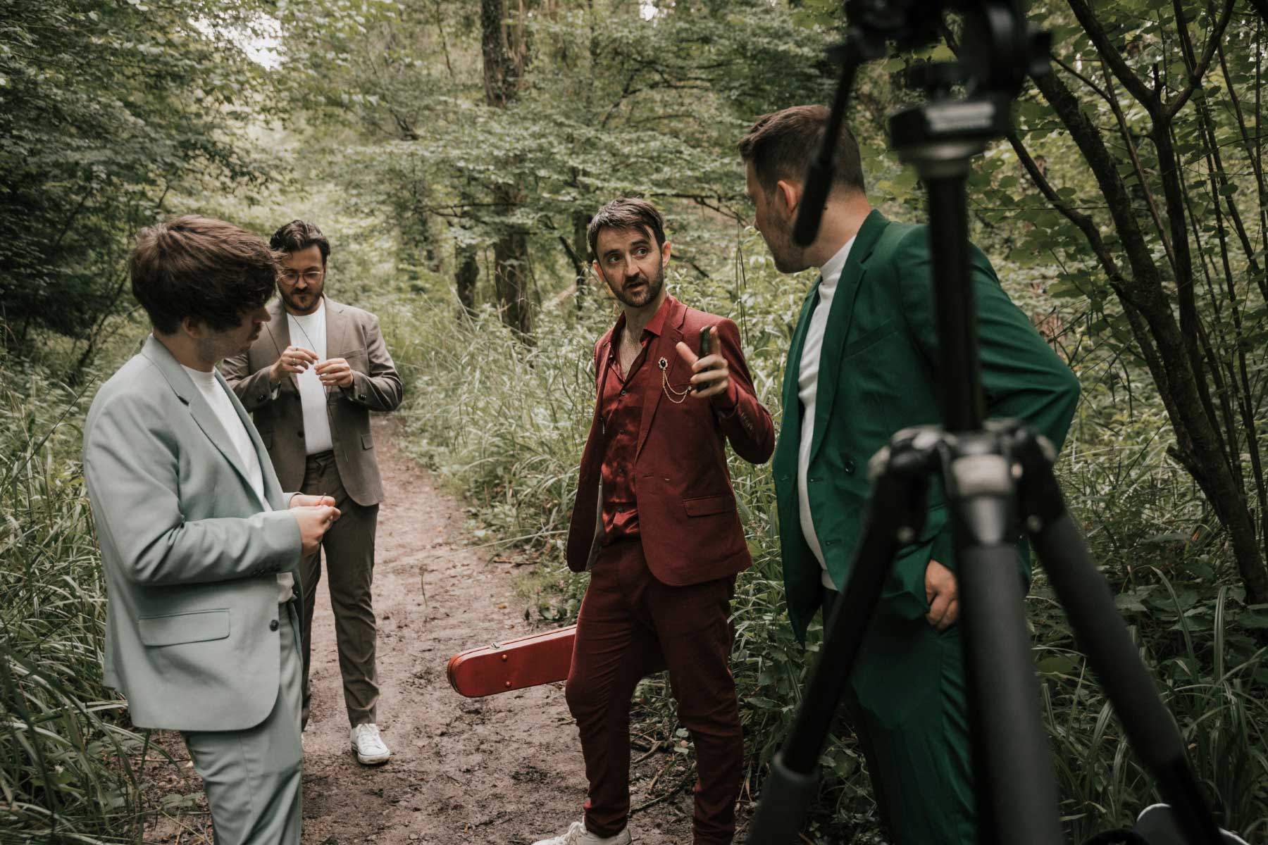 Candid shot of band in forest being directed for a music video