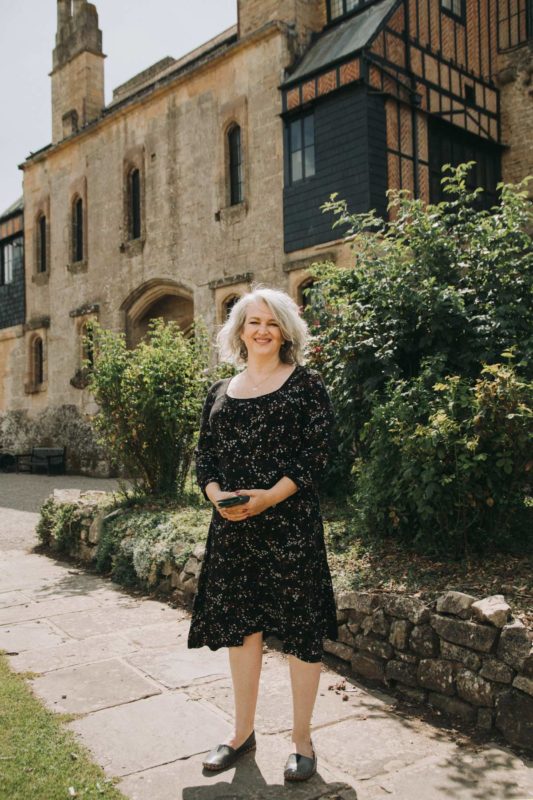 Female county councillor stood smiling happily in a castle courtyard