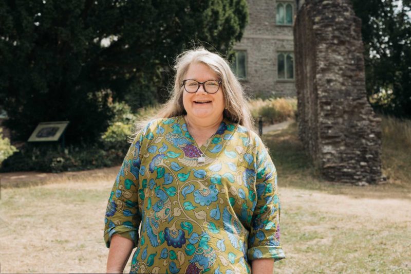 Smiling female councillor in floral shirt stood in the grounds of Abergavenny castle
