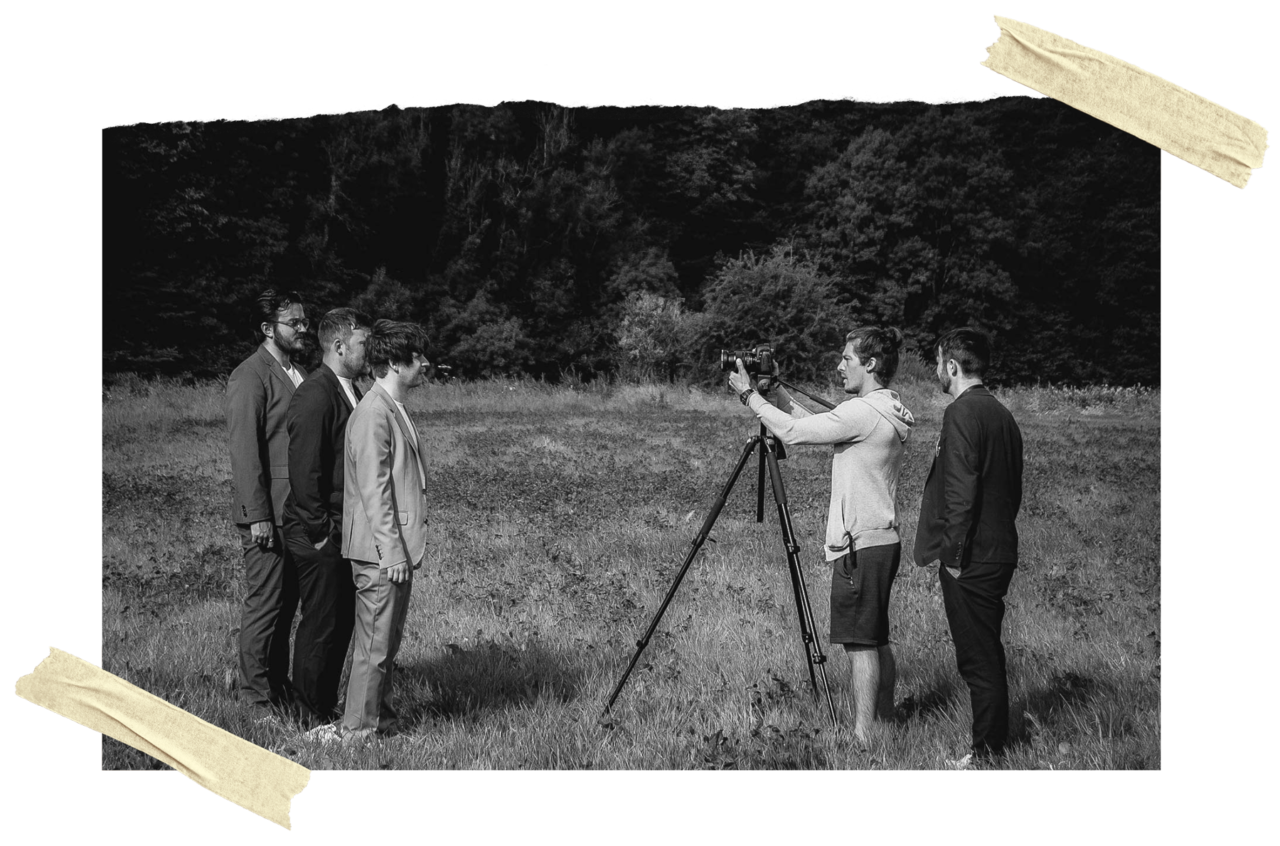 Tom Damsell stood behind a camera on a tripod while filming a Rusty Shackle music video