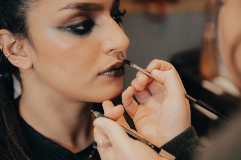 Close up of Sophie's lips having black lipstick applied