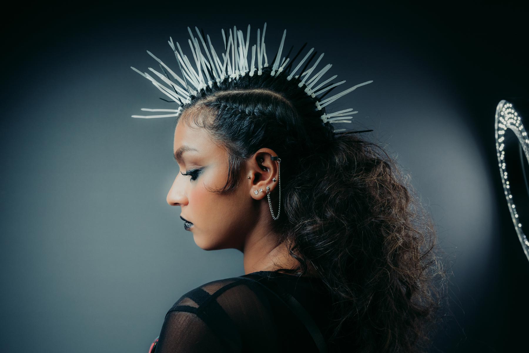 Shot from behind a model with her head turned to the side and illuminated by two spotlights