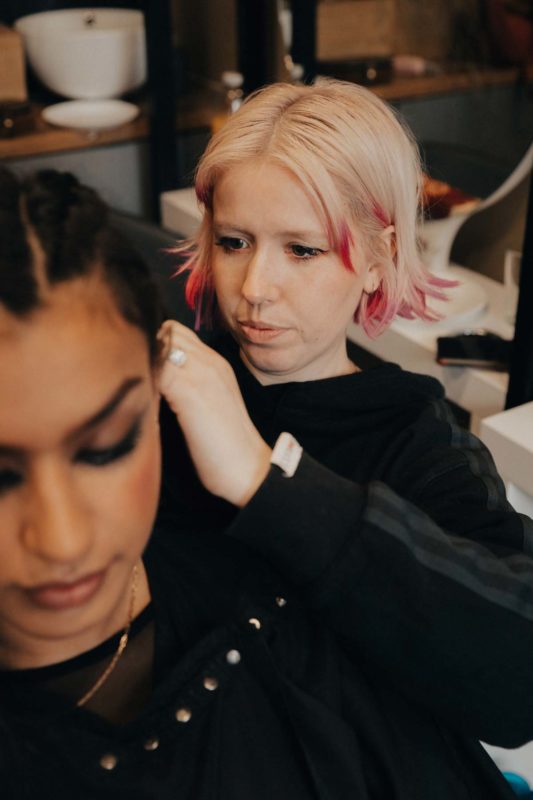 Close up of hannah working on Sophie's hair with a look on concentration