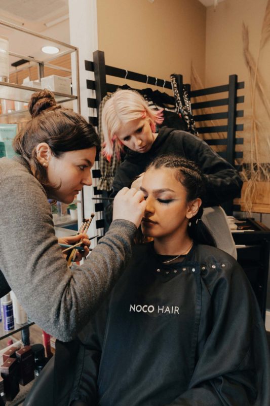 Sophie sat in a Noco chair with Hannah and Mariella working on her image