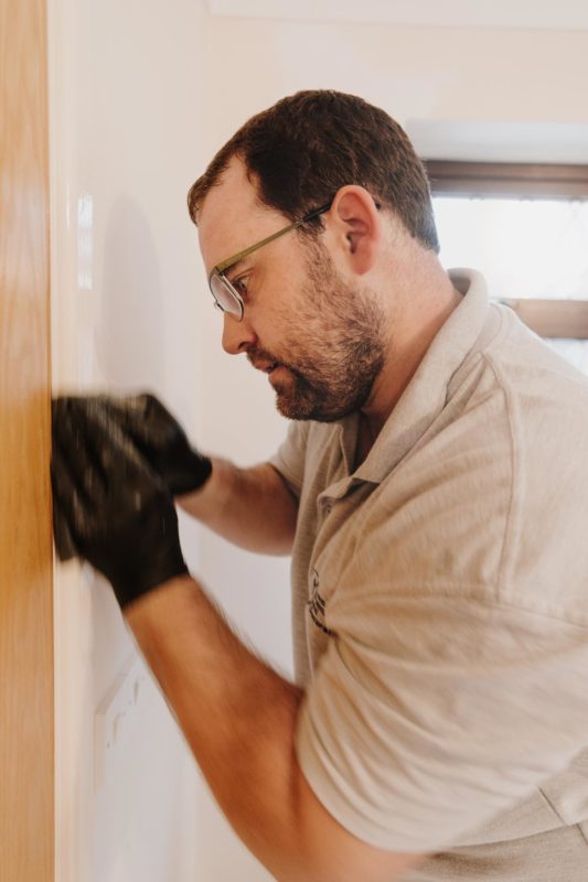 Decorator sanding down door frames with motion blur on hands