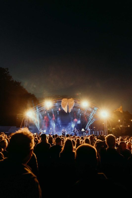 View of a huge stage from the back of a huge festival arena