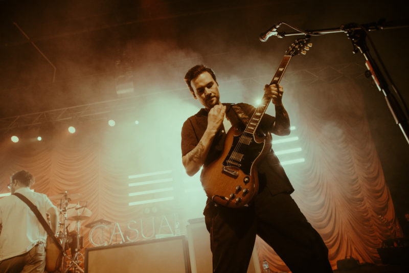 Kids In Glass Houses guitarist Joel Fisher stood playing in front of bright stage lights in Cardiff's Great Hall
