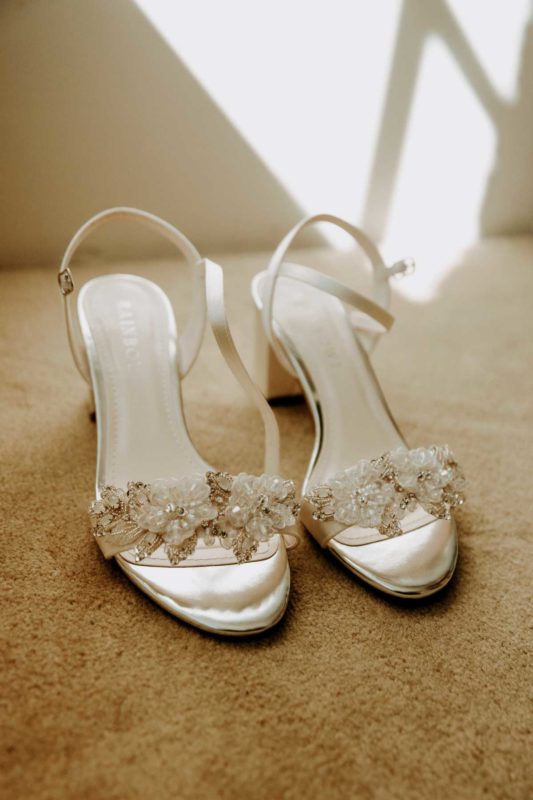Detail shot of bride's footwear against a sunlit wall