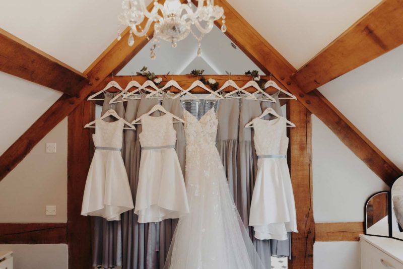 Bride and bridesmaid dressed hung from wooden rafters