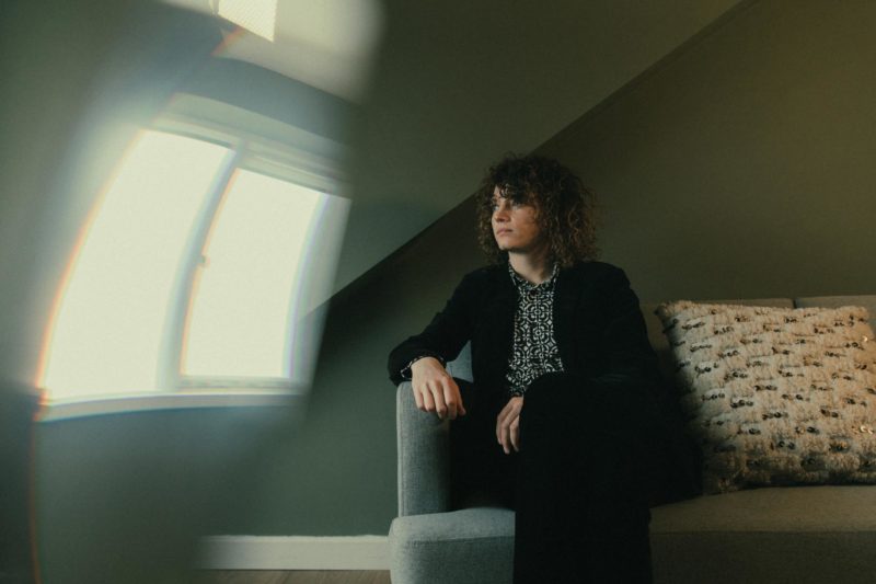 Alex from Twin Stranger sat on a sofa gazing out of the window