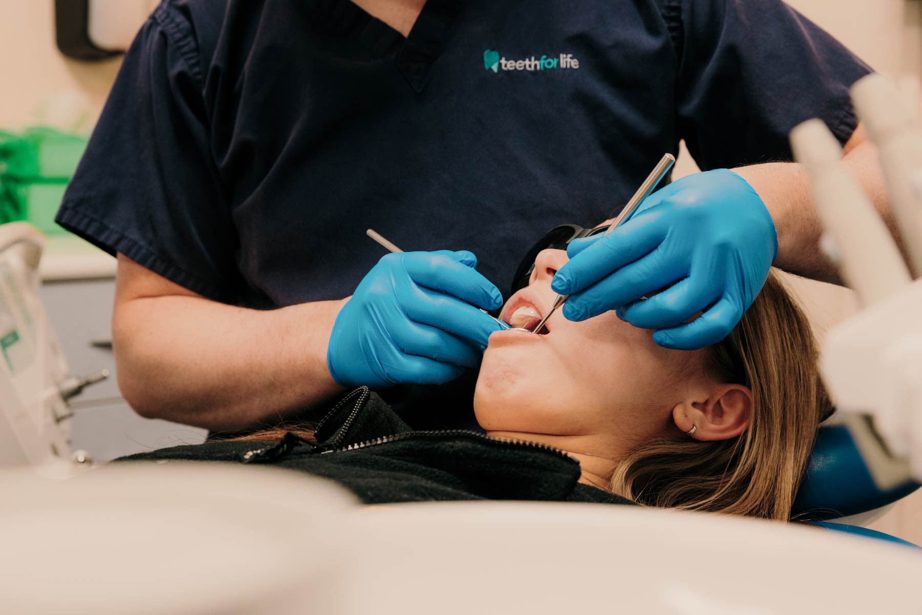 Close up of a Dentist's hands in blue gloves examining a patient's teeth. Shot for a marketing session for Teeth For Life in Caldicot, December 2023.