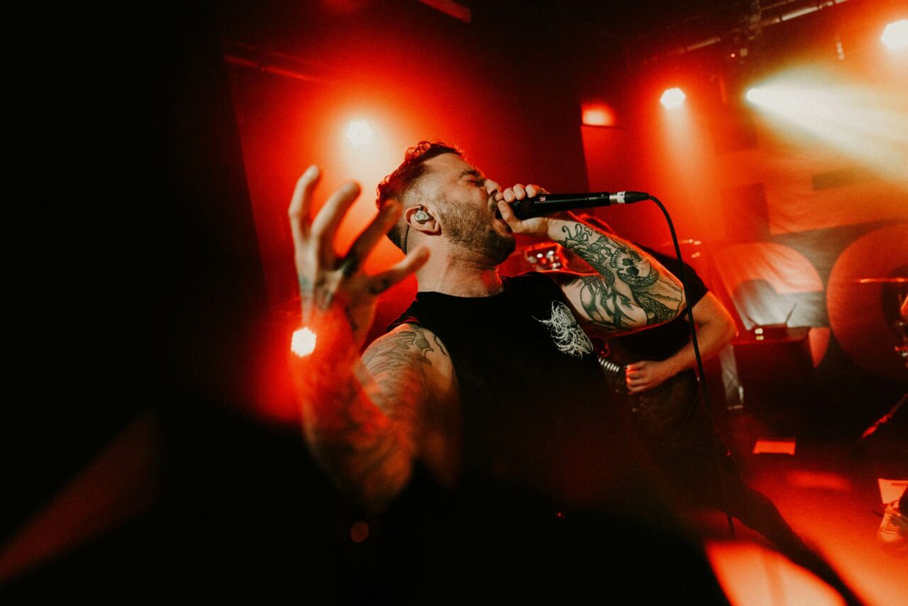 Heart of a Coward vocalist Kaan screaming into a micrphone in Clwb Ifor Bach, Cardiff.