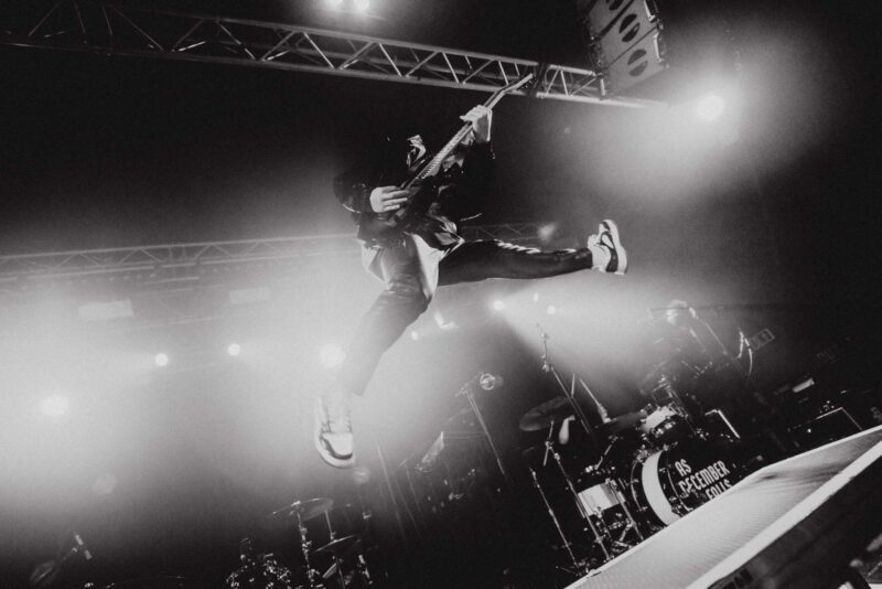 Blake Cornwall, guitarist of Lake Malice, mid-air while jumping on stage. Shot at Tramshed, Cardiff on the Rory tour, March 2025.
