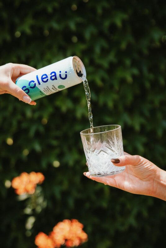 Lifestyle action product shot of a can of Soleau canned spring water being poured from a height into an ornate class. Shot on location in Usk for a promotional launch campaign.