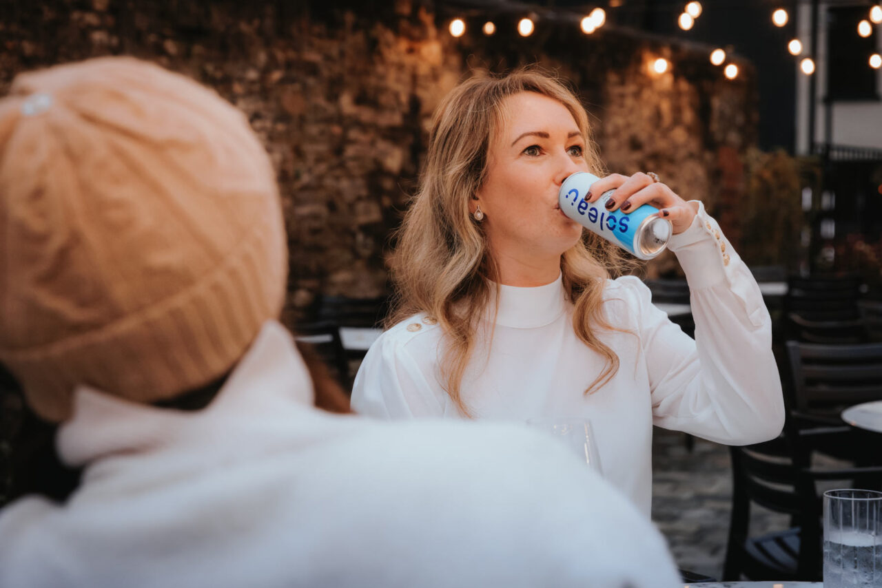 Product shot of a lady drinking from a can of Soleau spring water on a summer evening. Shot as part of a marketing shoot in Usk, South Wales.